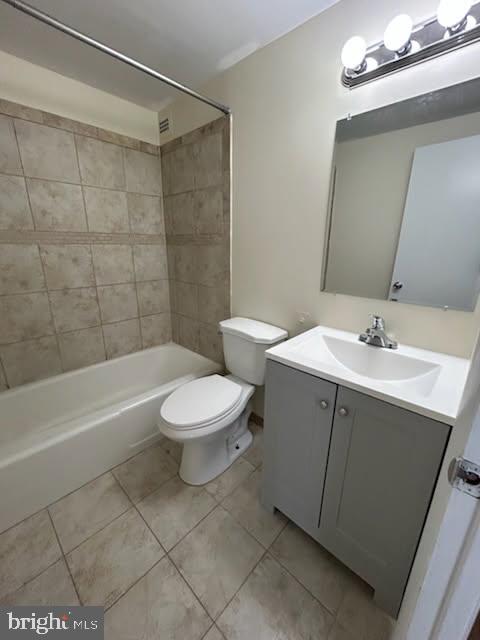 full bathroom featuring tile patterned flooring, toilet, vanity, and bathtub / shower combination