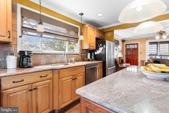 kitchen with a sink, hanging light fixtures, appliances with stainless steel finishes, crown molding, and tasteful backsplash