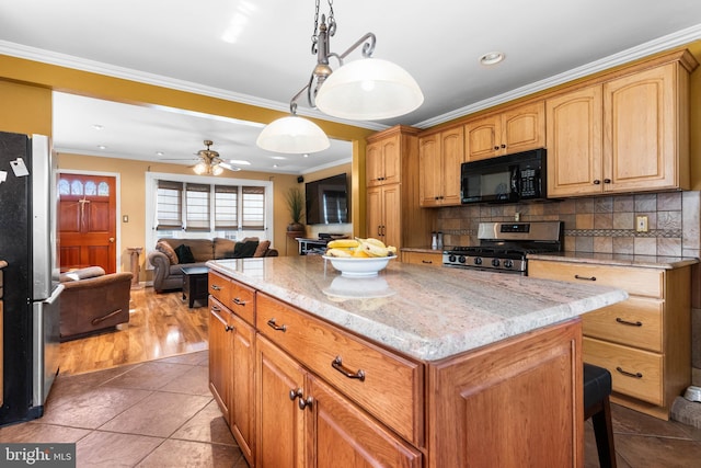 kitchen featuring light stone countertops, tasteful backsplash, appliances with stainless steel finishes, and ornamental molding