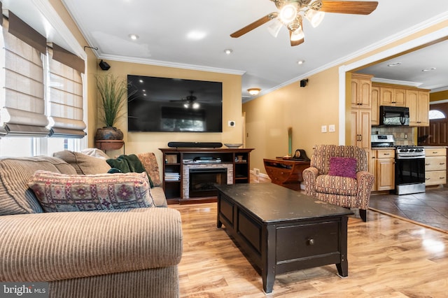 living area featuring plenty of natural light, a ceiling fan, and light wood-style floors