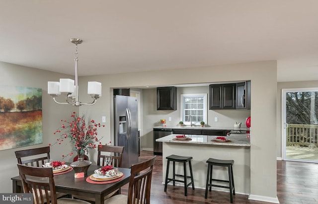 dining area featuring baseboards, an inviting chandelier, and dark wood-style flooring