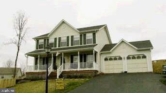 view of front of home with a porch, driveway, and a garage