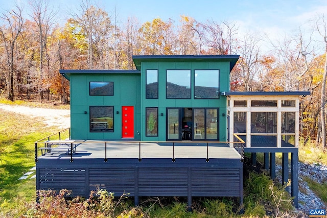 rear view of property with a jacuzzi and a sunroom