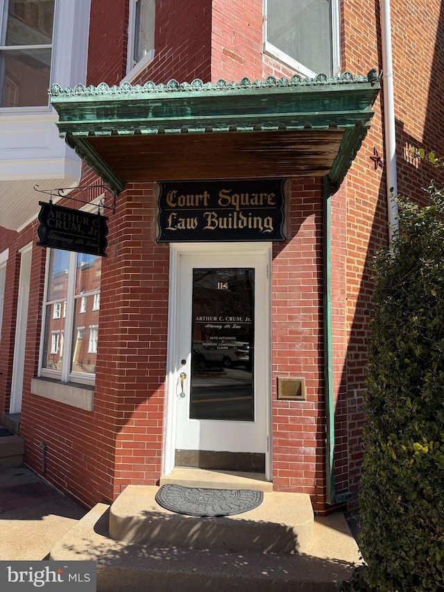 entrance to property featuring brick siding