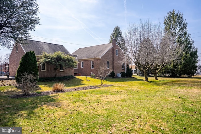 view of home's exterior with a lawn and brick siding