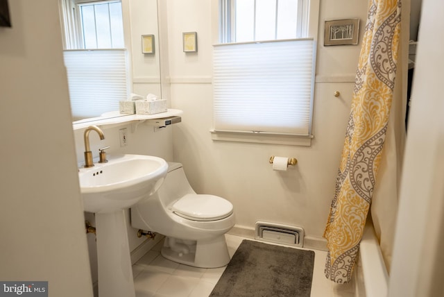 bathroom with tile patterned flooring, toilet, and baseboards