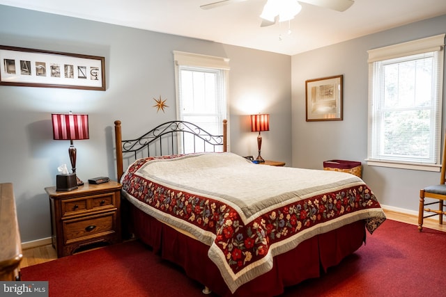 bedroom with ceiling fan, baseboards, and wood finished floors