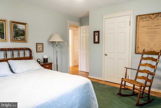 bedroom with wood finished floors and baseboards