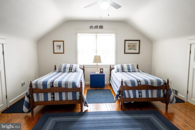 bedroom with vaulted ceiling, baseboards, and wood-type flooring