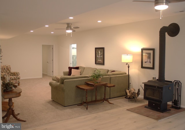 living area with a ceiling fan, visible vents, a wood stove, recessed lighting, and light wood-style floors