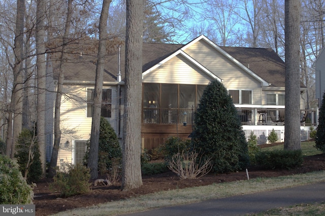 view of front of property featuring roof with shingles and a sunroom