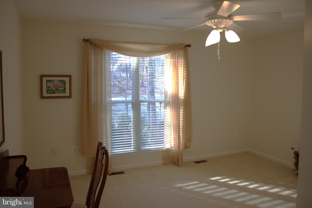 interior space with visible vents, baseboards, and ceiling fan