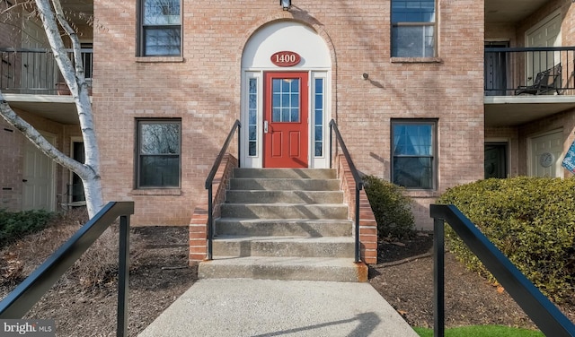 doorway to property featuring brick siding