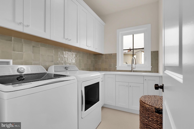laundry area with a sink, washer and clothes dryer, and cabinet space