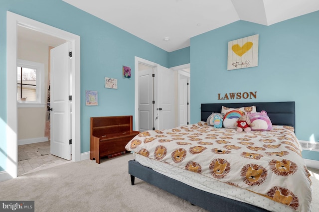 carpeted bedroom with baseboards and lofted ceiling