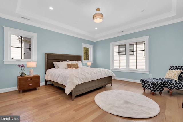 bedroom with baseboards, visible vents, light wood-style floors, and ornamental molding