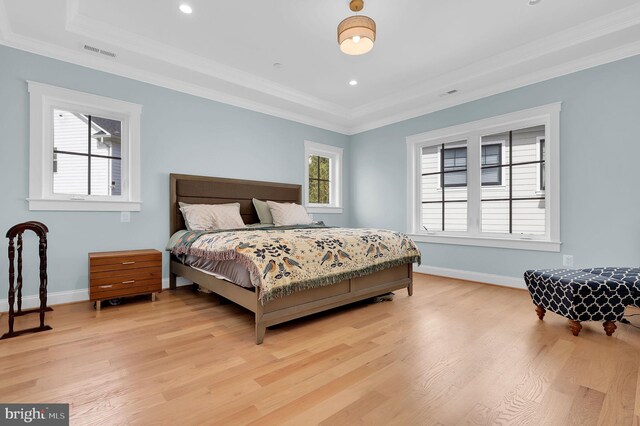 bedroom featuring light wood-style flooring, ornamental molding, baseboards, and visible vents