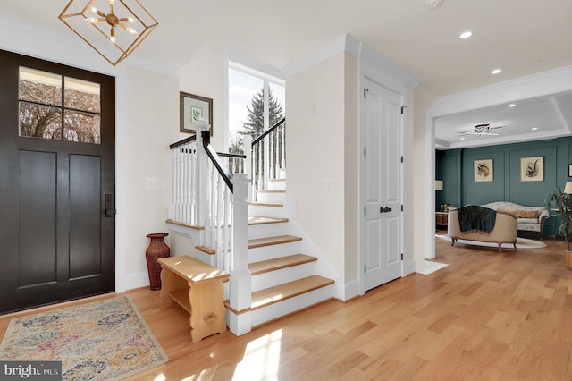 entryway featuring recessed lighting, light wood-type flooring, stairway, and crown molding