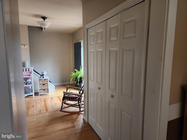 corridor with baseboards and hardwood / wood-style floors