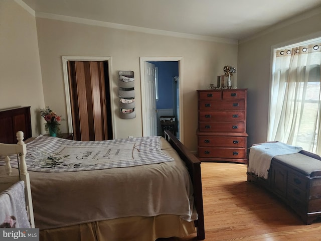 bedroom with light wood-style flooring and ornamental molding