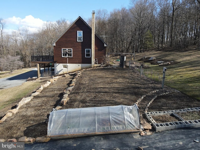 view of side of property featuring a deck, an exterior structure, and an outdoor structure