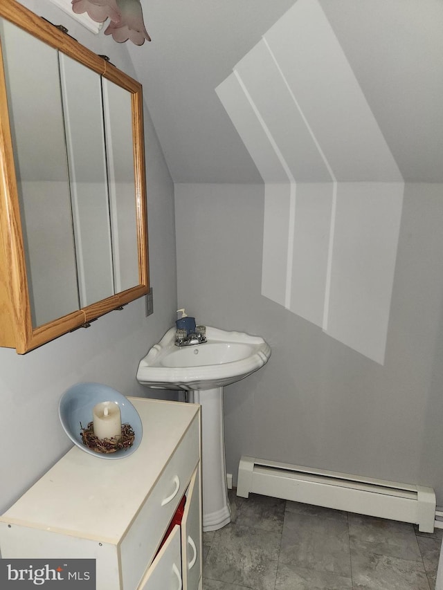 bathroom featuring a sink, a baseboard heating unit, and lofted ceiling