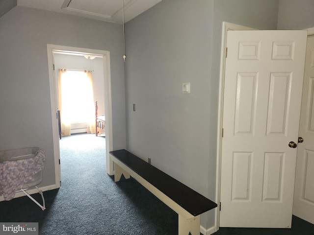 hallway with baseboards and dark carpet