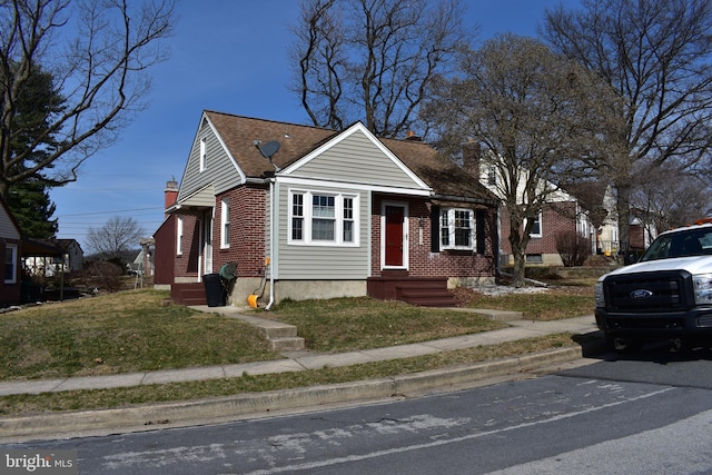 bungalow-style house with a front lawn, brick siding, and a chimney