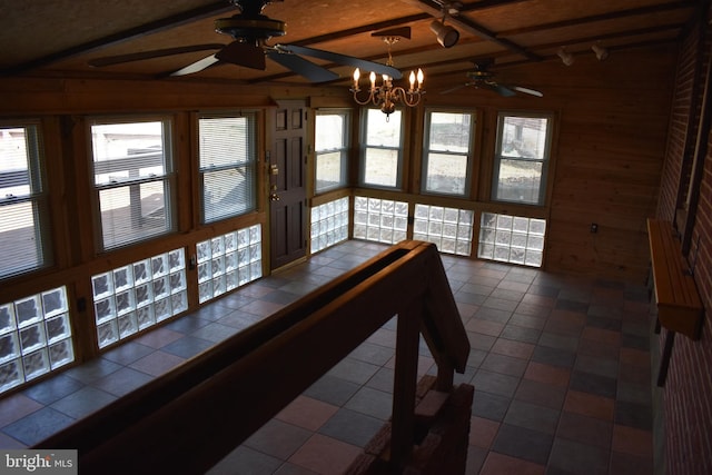 unfurnished sunroom featuring a ceiling fan