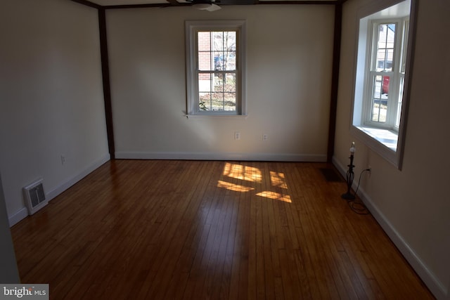 unfurnished room featuring visible vents, ceiling fan, baseboards, and hardwood / wood-style flooring