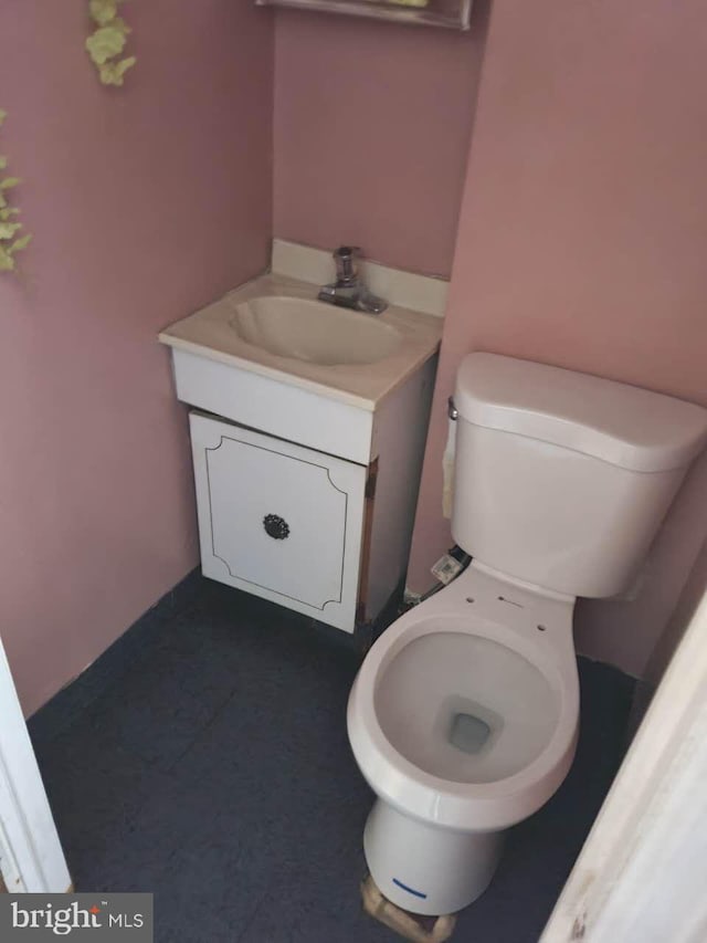 half bath featuring vanity and toilet