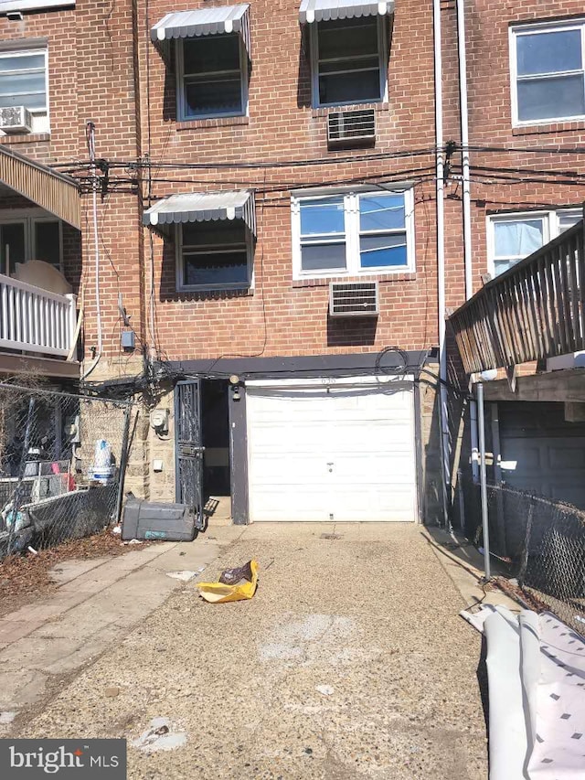 view of front of property featuring brick siding, cooling unit, driveway, and a garage