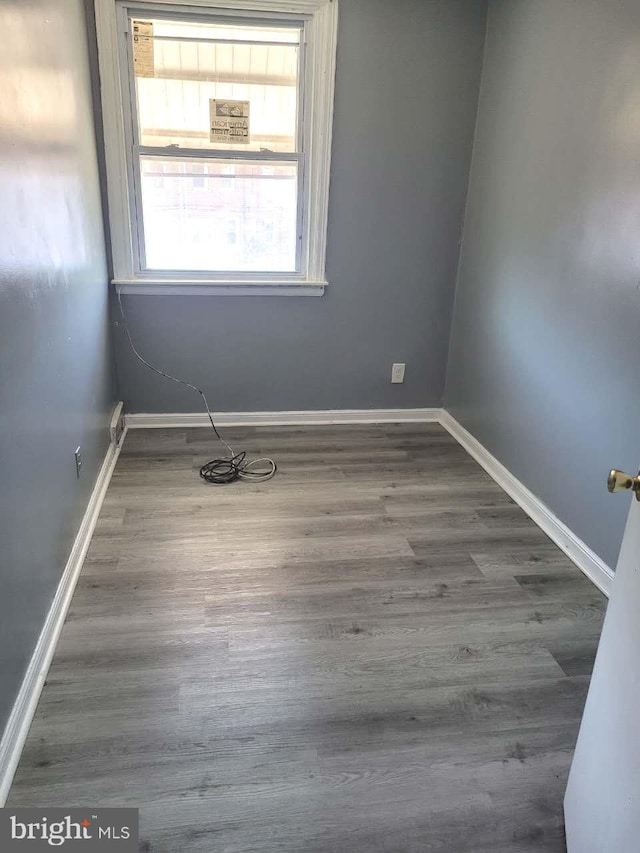 unfurnished room featuring baseboards and wood finished floors