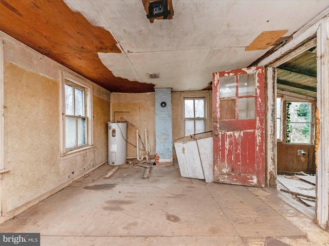 miscellaneous room with visible vents, plenty of natural light, and water heater