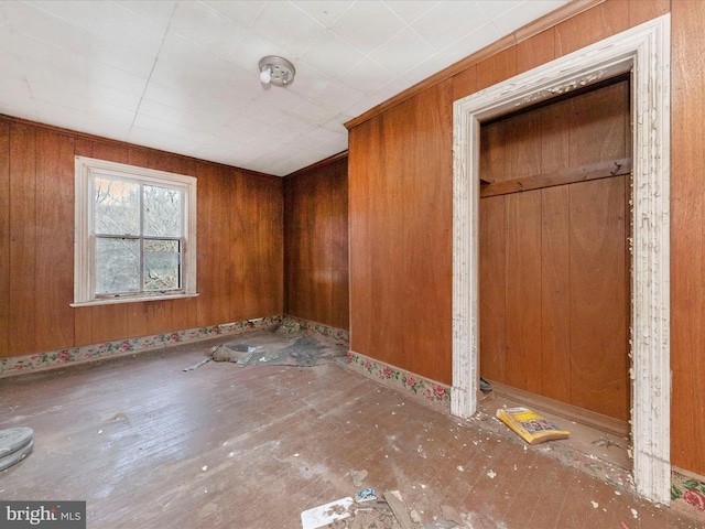 unfurnished room featuring wooden walls