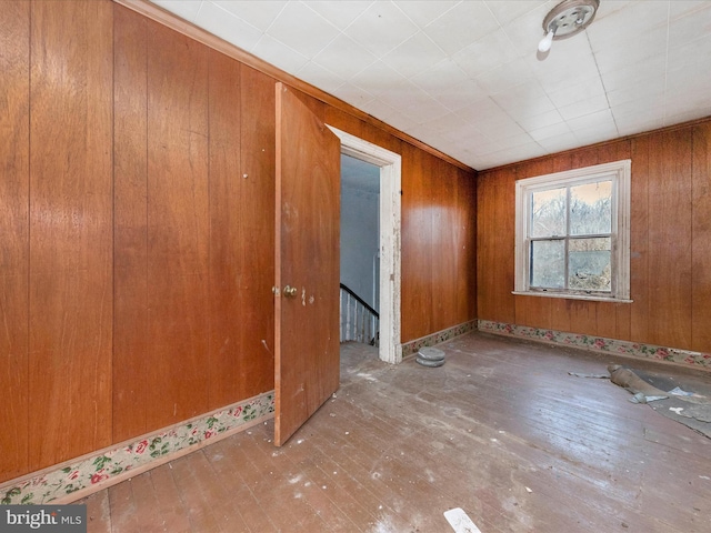 empty room featuring wood walls and wood-type flooring