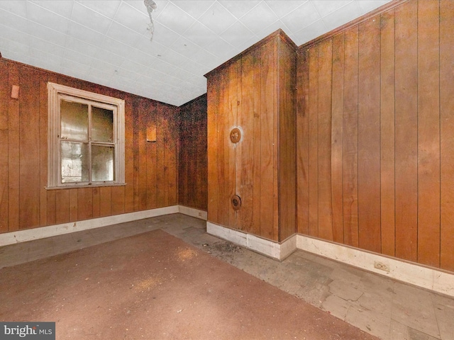 empty room with wooden walls and baseboards