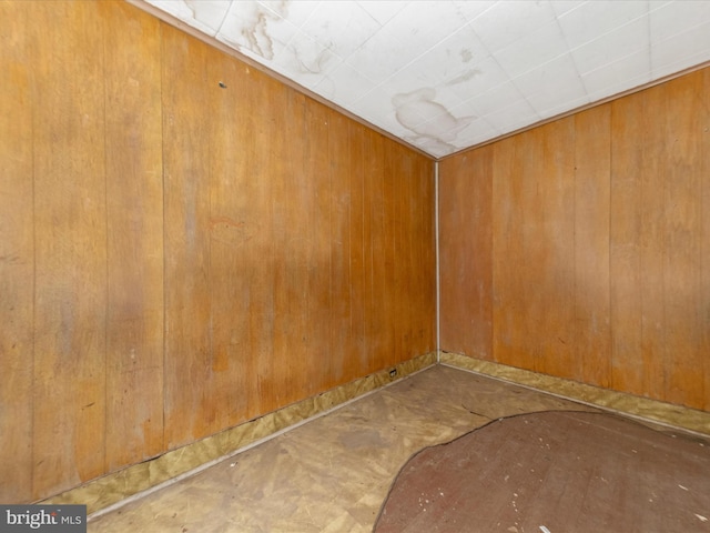 spare room with wood walls