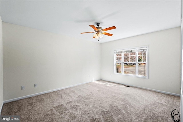 carpeted empty room featuring visible vents, baseboards, and ceiling fan