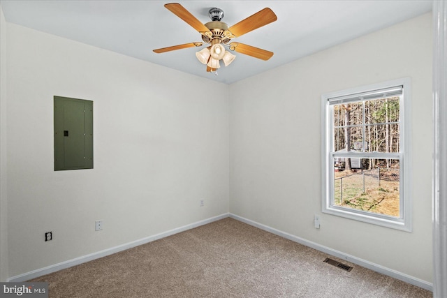 empty room with electric panel, visible vents, a healthy amount of sunlight, and carpet flooring