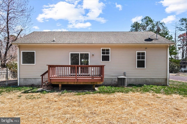 rear view of house with central AC unit, fence, roof with shingles, and a wooden deck