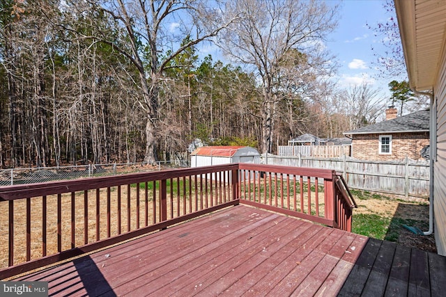 deck with a yard, a storage shed, a fenced backyard, and an outdoor structure