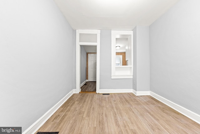 unfurnished bedroom with light wood-style floors, visible vents, and baseboards