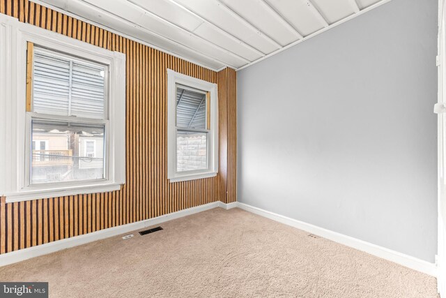 empty room featuring visible vents, baseboards, carpet flooring, and plenty of natural light