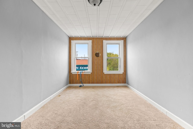 carpeted empty room with baseboards