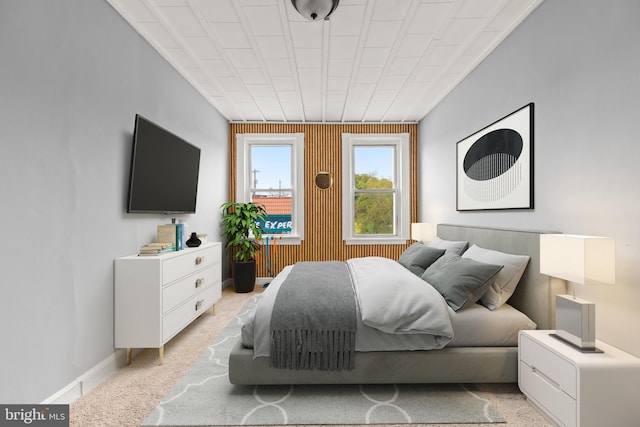 bedroom featuring baseboards and light colored carpet