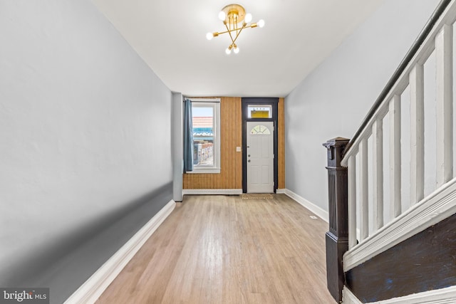 foyer featuring stairs, baseboards, wood finished floors, and a notable chandelier