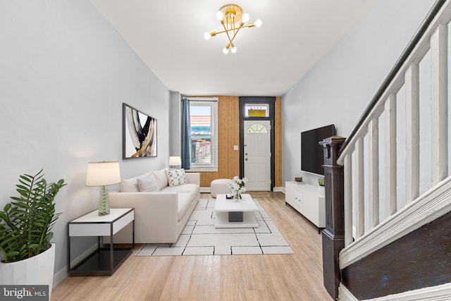 living room with stairway, an inviting chandelier, wood finished floors, and baseboards