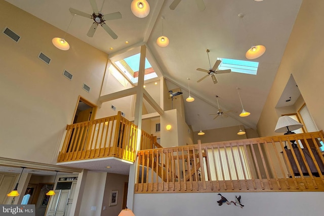 interior space featuring ceiling fan, visible vents, high vaulted ceiling, and a skylight