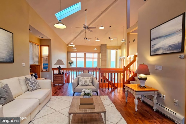 living room featuring ceiling fan, a skylight, wood finished floors, and a baseboard radiator